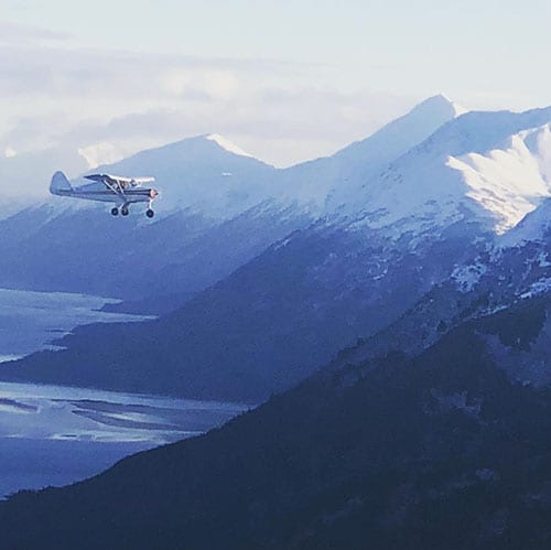 airplane flying by Alaskan mountains